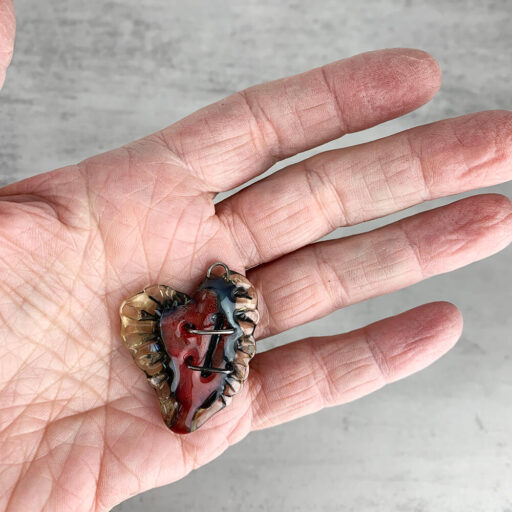 Winged Mended Heart Pendant in my hand