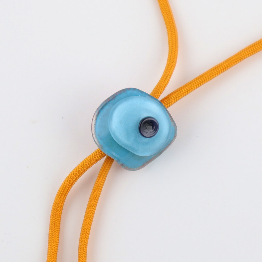 Dalí Disc slider bolo tie with merigold color paracord.